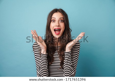 Photo of excited nice woman in striped sweater expressing surprise at camera isolated over blue wall