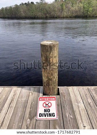 No diving warning along a dock on the river.