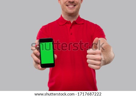 Delivery Man Holding Phone Showing Thumb Up Close Up. Home Delivery. Order Online Technology. Phone Green Screen