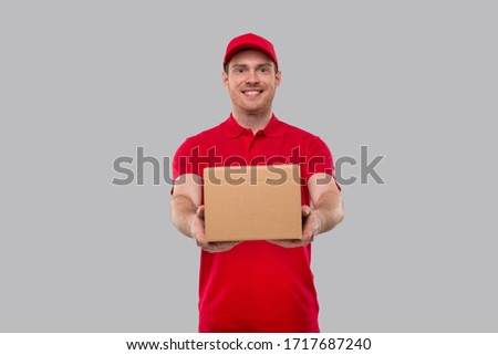 Delivery Man Box in Hands. Red Tshirt Delivery Boy. Home Delivery. Quarantine Hero. Royalty-Free Stock Photo #1717687240