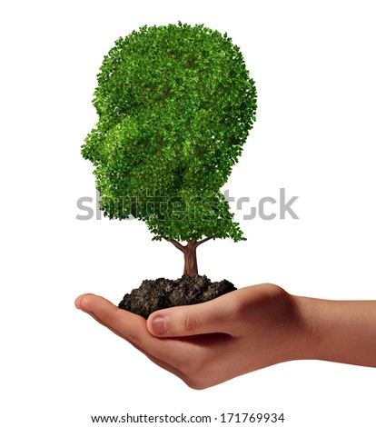 Life development concept with a hand holding a green tree shaped as a human head as a nurture metaphor and nature symbol for protection of the environment and growth potential.