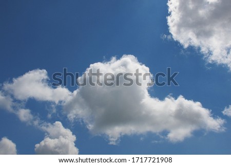  Puffy white summer clouds on a summer day in a bright blue sky