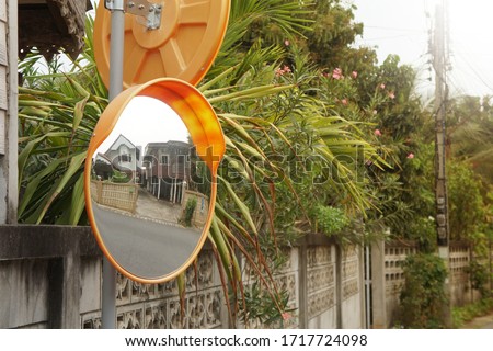 The concave mirror is attached to the corner of the street or opposite the house entrance.