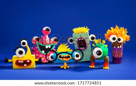 
Funny monsters from paper and plasticine on a blue background. Easy creative crafts for children.