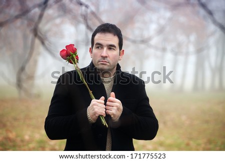 Man with red roses waiting for someone