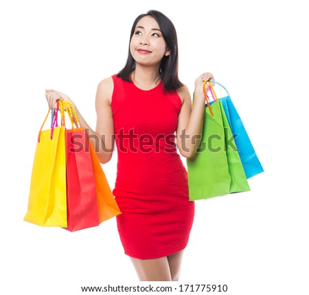 Young asian brunette woman with shopping bags on white background