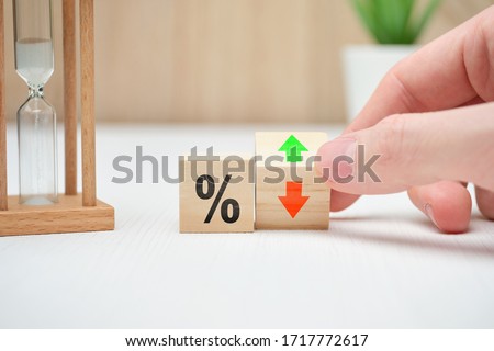 The concept of changing interest rates in banks falling and rising abstractly on wooden blocks. Close up. Royalty-Free Stock Photo #1717772617