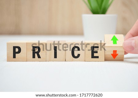 Concept of price change falling and rising abstractly on wooden blocks. Close up.