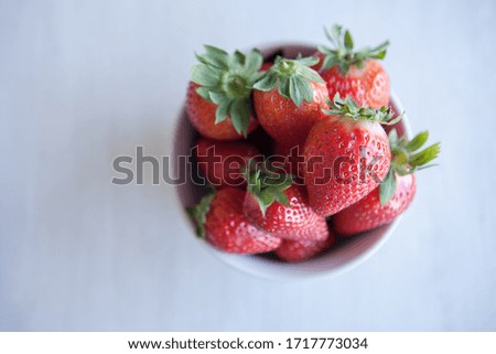 Strawberries in the ceramic bowl on the table. Natural day light. Top view