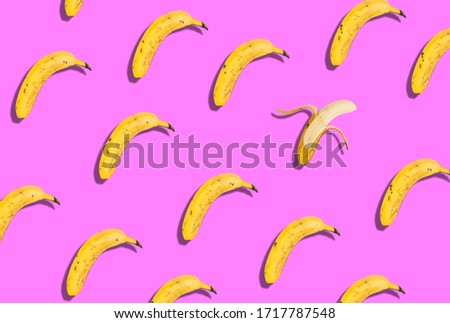 Banana pattern placed on a pink background. The pattern is broken by a peeled banana.