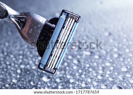 Razor close-up with water drops on a gray background. Royalty-Free Stock Photo #1717787659