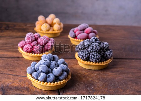 Frozen blueberries, blackberries, red and yellow raspberries in waffle tartlets.