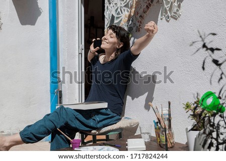 A young woman working at home and using her mobile phone