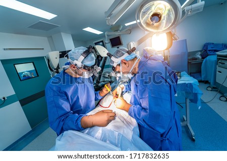 Spinal surgery. Group of surgeons in operating room with surgery equipment. Doctor looking at screen. Modern medical background Royalty-Free Stock Photo #1717832635