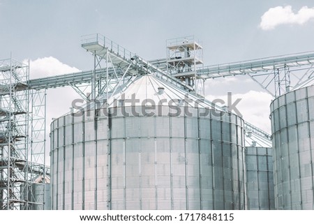 Building for storage, drying and processing of raw harvest products: grain, wheat, corn. Modern agriculture silos facility building. Crop processing plant. Grain warehouse tower. Agriculture business