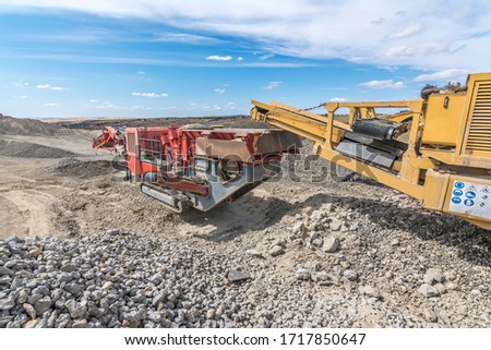 Heavy and mobile machinery in a quarry to transform stone into construction material