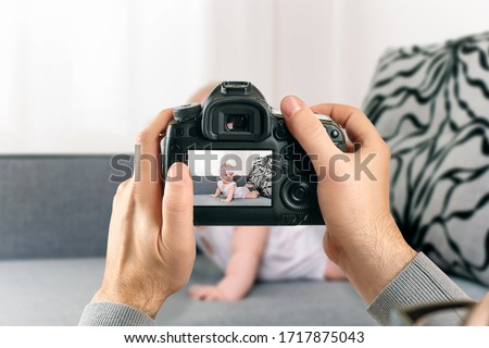 Digital single-lens reflex camera in hands. Man photographer makes photos. Male hands hold the camera close-up Royalty-Free Stock Photo #1717875043