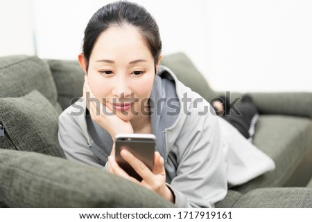 A woman using a smartphone on the sofa