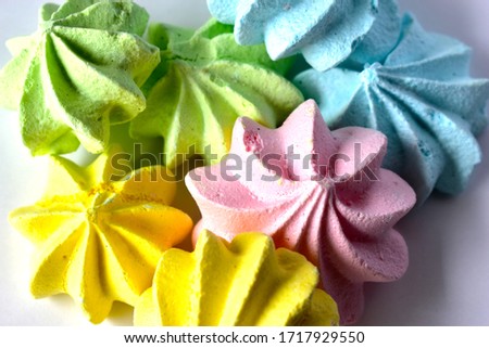 Multicolored meringue pieces on a white background. 