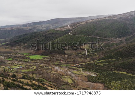 Turkish village, fields and road on the mountain slope on a cloudy day