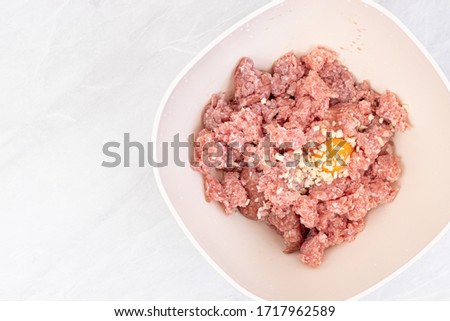 Raw minced meat with smashed eggs and chopped onion mixture for meatballs