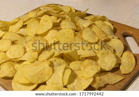 chips junk food unhealthy life style concept picture with wooden tray and table background  