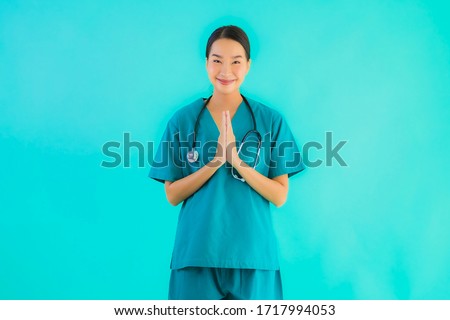 Portrait beautiful young asian doctor woman happy smile with sawasdee for work in hospital and clinic on blue isolated background