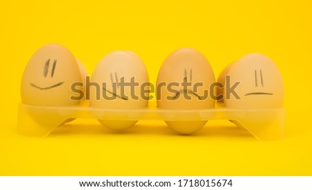 Chicken eggs with pronounced emotions close-up,on a light background,smiling and rejoicing and sad.