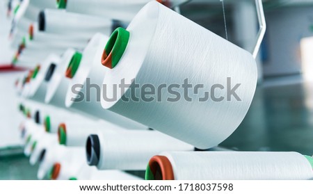 Textile industry - yarn spools on spinning machine. Royalty-Free Stock Photo #1718037598
