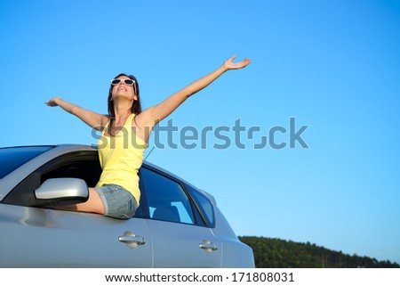 Joyful woman on car summer roadtrip. Blissful girl having fun on travel.