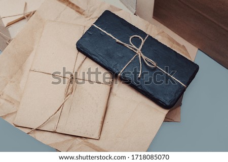 Slate stems lie on kraft paper on cardboard boxes. Present. Eco packaging concept. Grey background