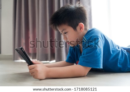 asian chinese boy playing tablet, addicted game and cartoon, 
