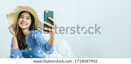 wide banner with copy space. happy pretty woman taking selfie with fashion hat and video call on mobile phone at home, summer holiday vacation, internet technology, social network, quarantine concept