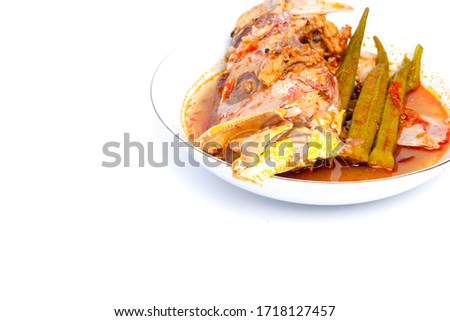 A high key picture of red snapper "asam pedas" on copy space white background.  "Asam pedas" is sour soup made from tamarind, chilli and spices that is popular in Malaysia and Indonesia.