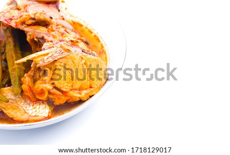 A close up picture of red snapper "asam pedas" on copy space white background.  "Asam pedas" is sour soup made from tamarind, chilli and spices that is popular in Malaysia and Indonesia.