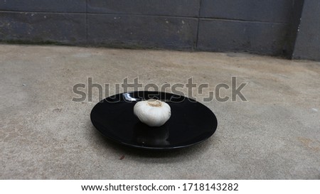 Garlic on black plate, photographed from the side 