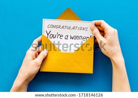 Congratulations You're a winner. Hands holding envelope with letter. Blue background top view Royalty-Free Stock Photo #1718146126