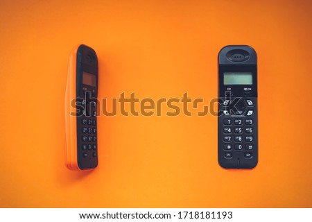 Two wireless cordless telephone, radiotelephone, dect cordless phone wireless phone, radiotelephone, radio phone on orange background Royalty-Free Stock Photo #1718181193
