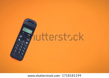Wireless cordless telephone, radiotelephone, dect cordless phone on orange background. Copy space Royalty-Free Stock Photo #1718181199