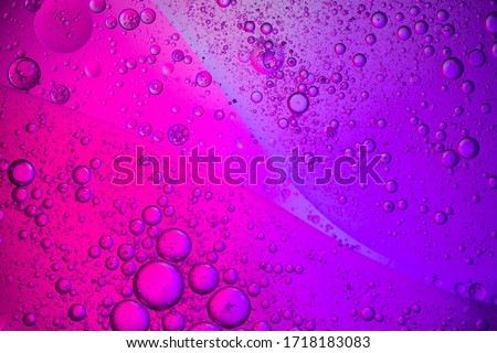 Abstract color background. Bubbles of oil in a colored liquid and lighting in macro photography in the laboratory. Living cell and scientific experiments concept.