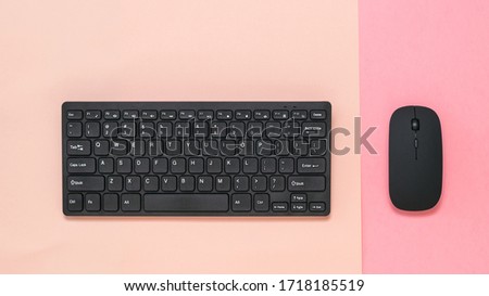 Wireless keyboard on a pink background and wireless mouse on a red background. 