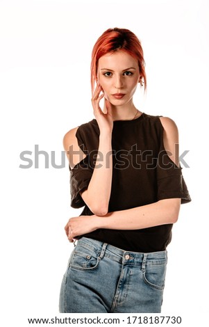 Studio body shot of a trendy young redhead  woman wearing modern style pants and black t-shirt