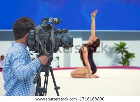 Camera shooting live broadcast from gymnastics game to television and internet on the background blured Unidentified women gymnast