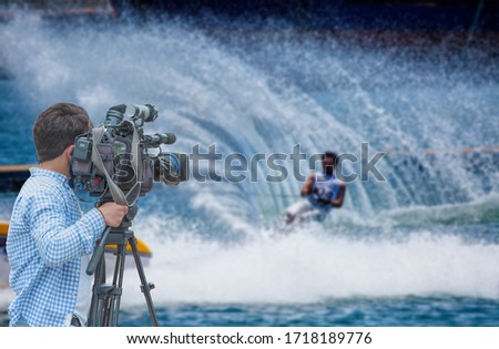 Cameraman shooting live broadcast from sport game to television and internet on the background blured Unidentified sportsman 