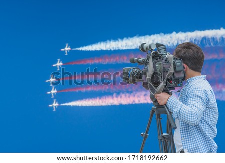 Cameraman shooting live broadcast from to television and internet on the background blured airplane