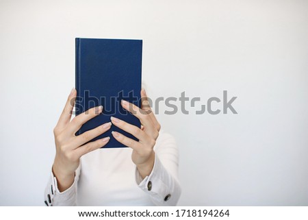 A young girl holds a book in her hand