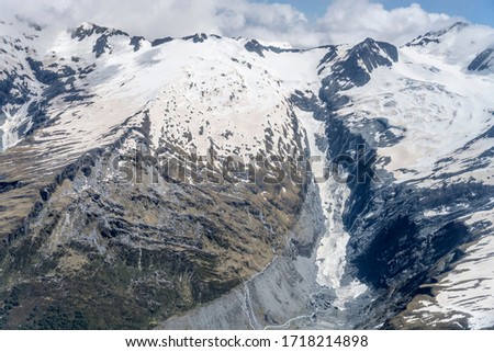aerial, from a glider, with steep slopes and glacier of Brewster peak, shot in bright spring light from south, Otago, South Island, New Zealand
