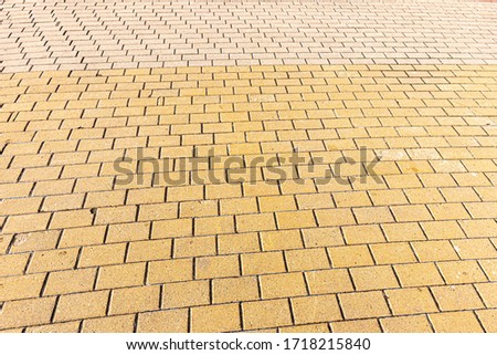 Top view on orange paving stone road. Old pavement of granite texture. Street cobblestone sidewalk. Abstract background for design.