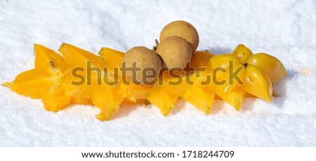 Carambola cut with a knife and a longan. Exotic fruit