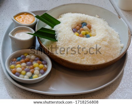 Fusion dessert bingsu in thai style (shave ice) with colorful bubbles (bua loi), salty egg sauce and coconut milk. Cold dessert best for summer.